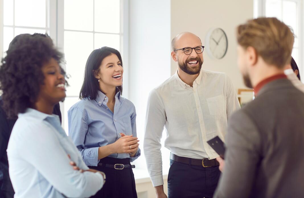 Multicultural group of happy business people standing together and laughing, close-up.