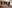 Young romantic multiethnic couple sitting on sofa in front of fireplace at home, looking at each other