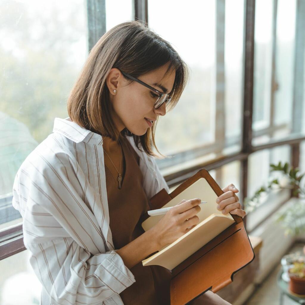 Young woman with glasses reading a book