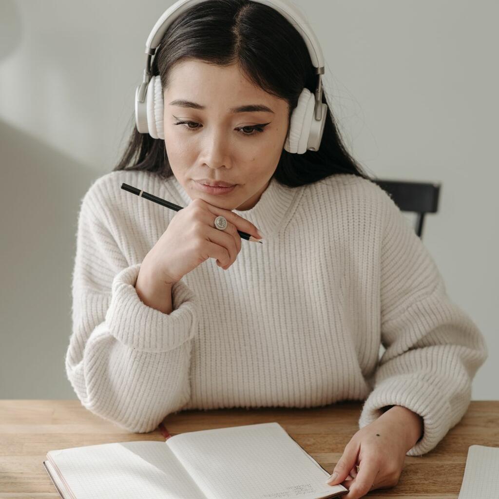 Woman listening to headphones and working